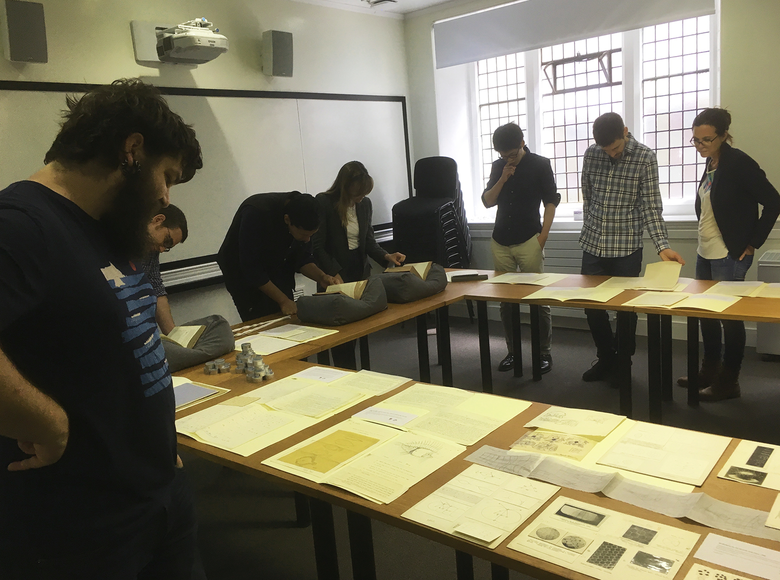 Workshop attendees looking at archive material displayed on tables